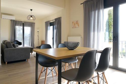a dining room with a table and chairs at Aellō luxury apartments in Markopoulo