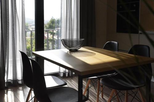 a table with chairs and a bowl on it in front of a window at Aellō luxury apartments in Markopoulo