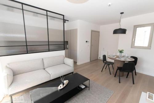 ein Wohnzimmer mit einem weißen Sofa und einem Tisch in der Unterkunft Modern apartment close to Athens city center (Form_F2) in Athen