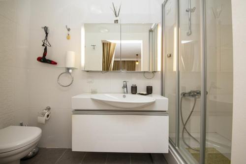 ein weißes Bad mit einem Waschbecken und einer Dusche in der Unterkunft Enchanting House with Backyard in Bodrum in Bodrum City