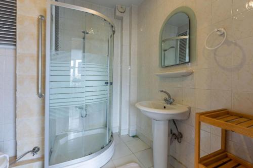 een badkamer met een glazen douche en een wastafel bij Contemporary in Istanbul