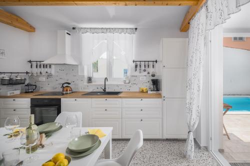 une cuisine avec des placards blancs et une table avec des assiettes. dans l'établissement Spacious holiday house in Istria, à Peroj