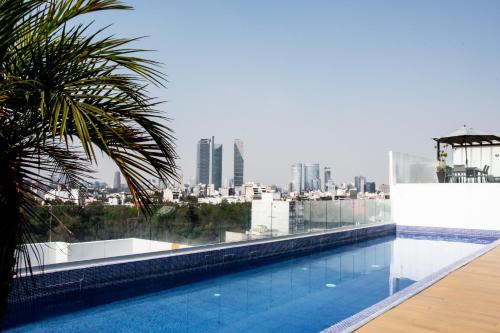 een zwembad op het dak van een gebouw met een stad bij New apartments in building with pool, rooftop and gym in Condesa in Mexico-Stad