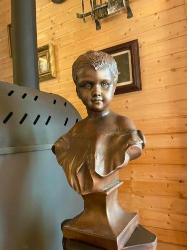 a bronze statue of a boy holding a fish at Villa Luca in Mosonmagyaróvár