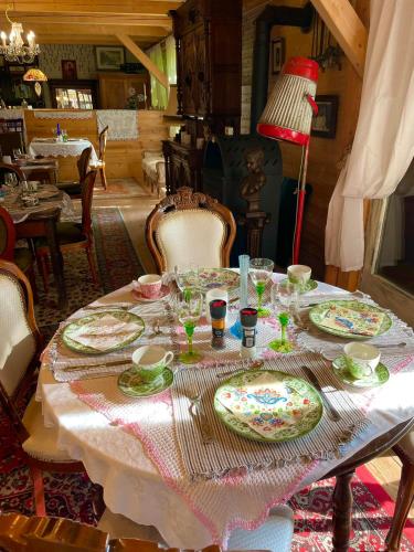 a table with plates and glasses and a red lamp at Villa Luca in Mosonmagyaróvár