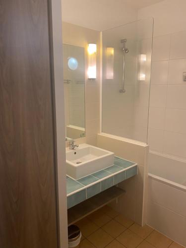 y baño con lavabo y espejo. en appartement vue mer 50m de la plage, WIFI gratuit en Perros-Guirec