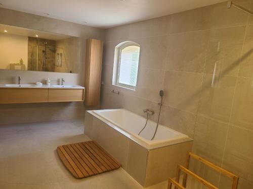 ein Badezimmer mit einer Badewanne und einem Waschbecken in der Unterkunft Villa Mycènes in Garéoult