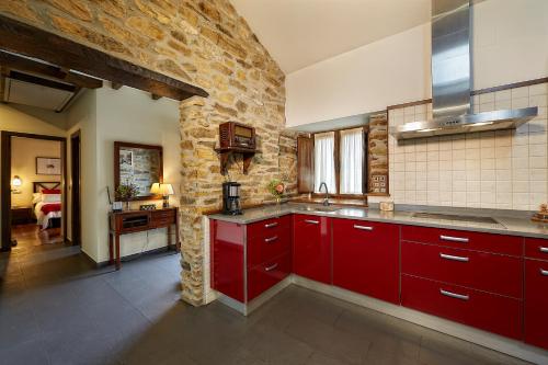 a kitchen with red cabinets and a stone wall at La Era De Somao in Somado