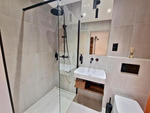 a bathroom with a glass shower and a sink at Penzion San Martin in Martin