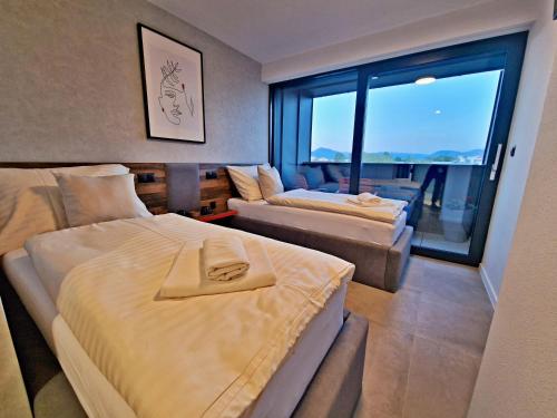 ein Schlafzimmer mit 2 Betten und einem Sofa und einem großen Fenster in der Unterkunft Penzion San Martin in Martin
