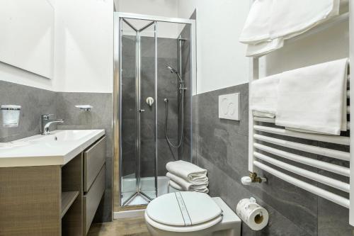 a bathroom with a shower and a toilet and a sink at Hotel Anna Siena Nord in Siena