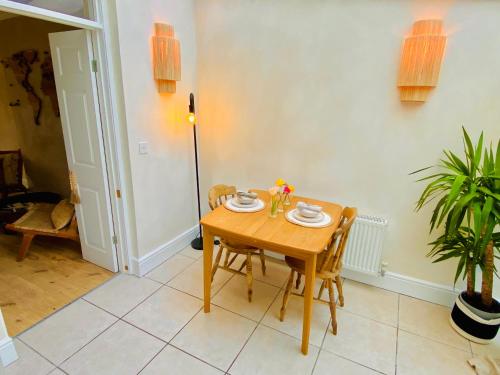 uma sala de jantar com uma mesa de madeira e cadeiras em Beautiful Boho in Bridgend em Bridgend