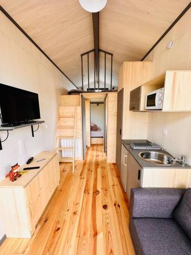 a small kitchen with wooden flooring in a tiny house at tiny house in Cholet