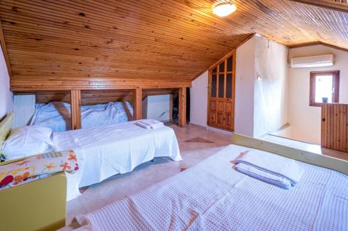 a bedroom with two beds and a wooden ceiling at Wonderful Home Close to Beach in Fethiye in Fethiye