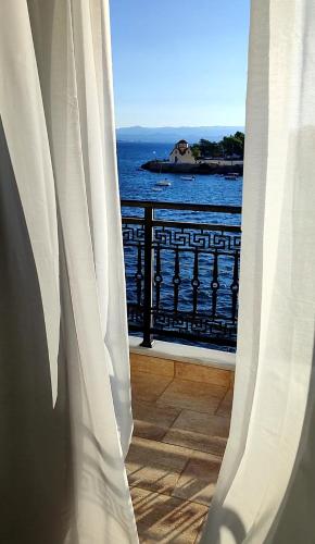 a window with a view of the ocean from a balcony at atoll 'Paris-Alexandre' in Gythio