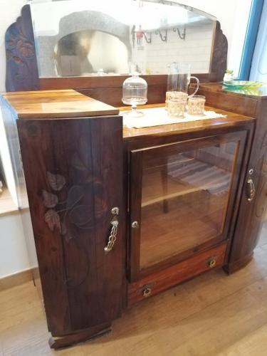 an old wooden cabinet with a glass door at Ti Chôa - Casa da Praça in Angra do Heroísmo