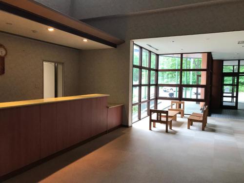 a lobby with a counter and chairs and windows at Aizu Kogen International Human Resources Center - Vacation STAY 44530v in Minamiaizu
