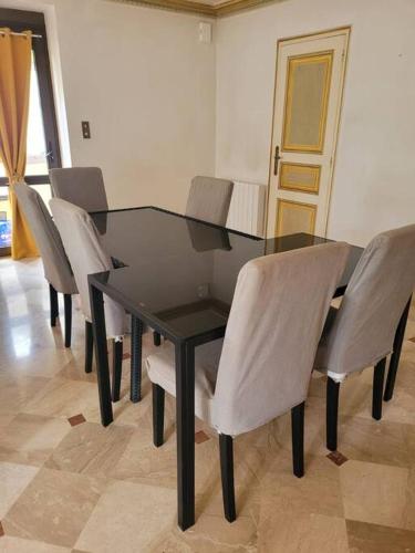 a dining room table with chairs and a black table at Le Castel - Dormir Comme à La Maison - in Châteaubriant
