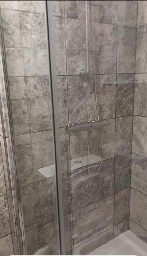 a shower with a glass door in a bathroom at Heronsgate GH013 in Erith