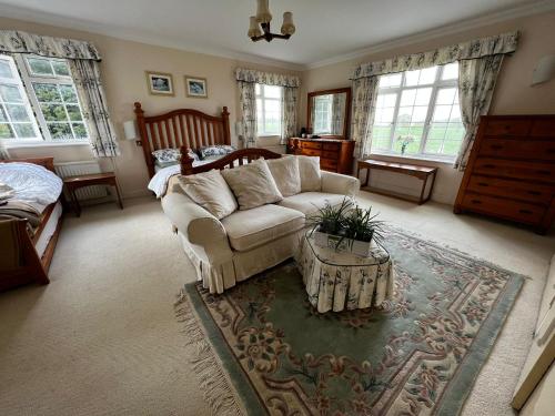 a living room with a couch and a bed at Plumpton House in Ashford