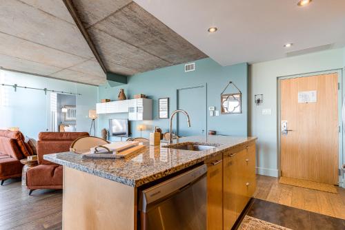 a kitchen with a sink and a living room at Les Immeubles Charlevoix - Le 760412 in Quebec City