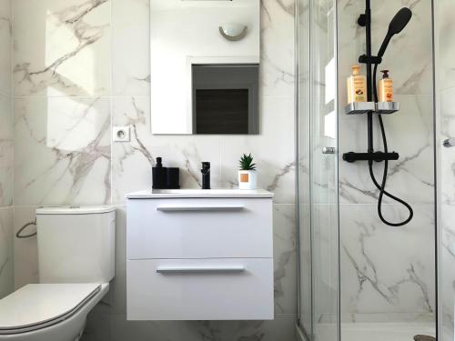 La salle de bains blanche est pourvue d'une douche et de toilettes. dans l'établissement COSY VAUTRIN, Appartement ensoleillé à 100m de la Mer, à Cannes