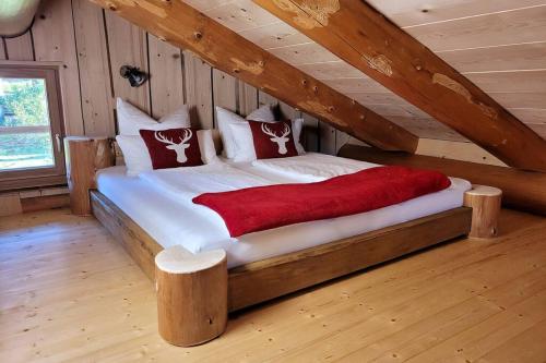 a large bed in a room with wooden walls at Chalet Enzian Bayerwald in Arnbruck