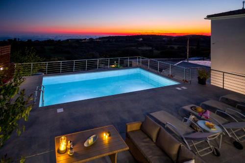 a swimming pool on the roof of a building with a sunset at The View Villa in Maryiés