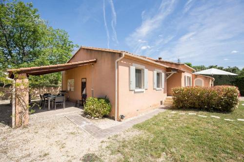 une petite maison avec un patio et une table dans l'établissement Villa piscine Lou Pitchoun, à Saint-Saturnin-lès-Apt