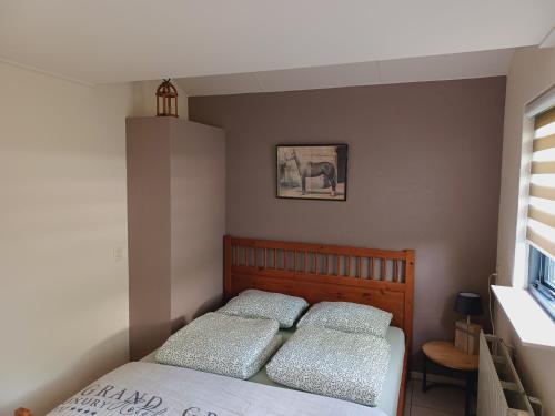 1 dormitorio con 1 cama con 2 almohadas en Klein Horst - vrijstaande bungalow - Ermelo, en Ermelo