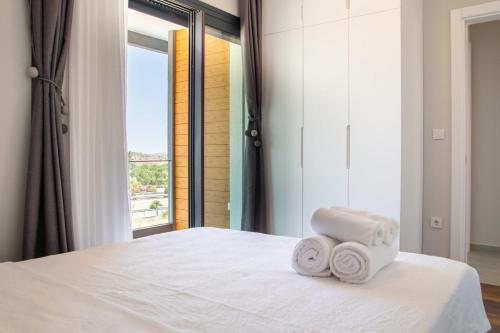 una camera da letto con un letto bianco e asciugamani di Amazing Villa with Private Pool in Alacati Cesme ad Alaçatı