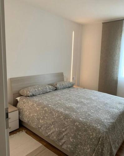 a bedroom with a bed with a gray comforter at Casa S. Caterina in Piaia