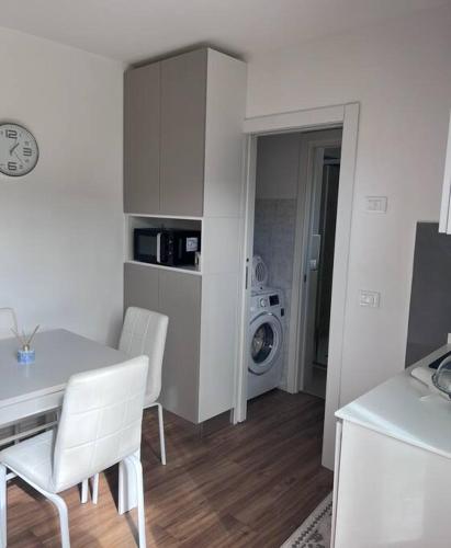 a kitchen with a table and chairs and a washing machine at Casa S. Caterina in Piaia