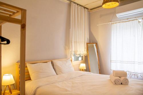 Schlafzimmer mit einem Bett mit weißer Bettwäsche und einem Fenster in der Unterkunft Authentic House in Izmir