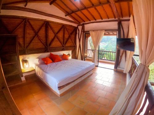 a bedroom with a bed in a room with a balcony at Cabañas el Nopal in San Gil