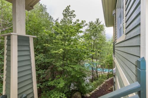 a view from the balcony of a house with trees at Tremblant Les Eaux by Rendez-Vous Mont-Tremblant in Mont-Tremblant
