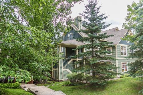 a house with a pine tree in front of it at Tremblant Les Eaux by Rendez-Vous Mont-Tremblant in Mont-Tremblant