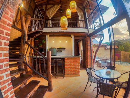 Una casa con escalera dispone de cocina y zona de comedor. en Cabañas el Nopal, en San Gil