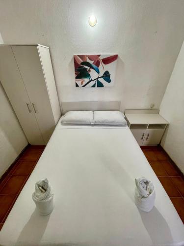 a large white bed in a small room at Hostal Inn 1 in Flores