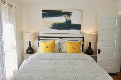 een slaapkamer met een bed met gele kussens bij Cozy 2 BDRM Vacation Rental - 1 Mile to Dtwn Rapid City in Rapid City