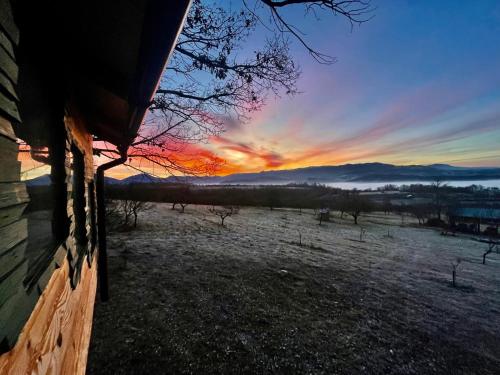 a sunset from a house with a view of a field at Langaland Glamping in Susenii Bîrgăului