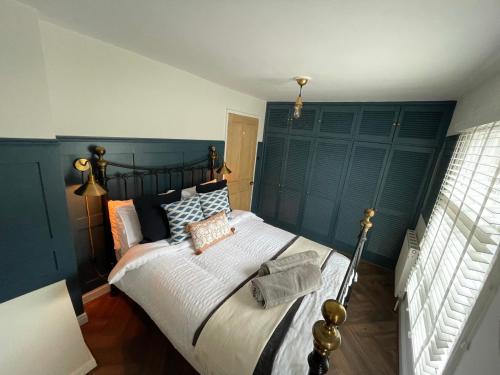 een slaapkamer met een groot bed met een blauw hoofdeinde bij The Railway Cottage Bridgnorth in Bridgnorth