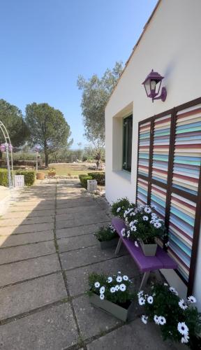 a purple bench next to a building with flowers at Borgo alto - Ideal holiday for families & friends in Noto