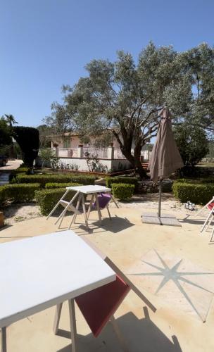 a table and an umbrella and a table and chairs at Borgo alto - Ideal holiday for families & friends in Noto