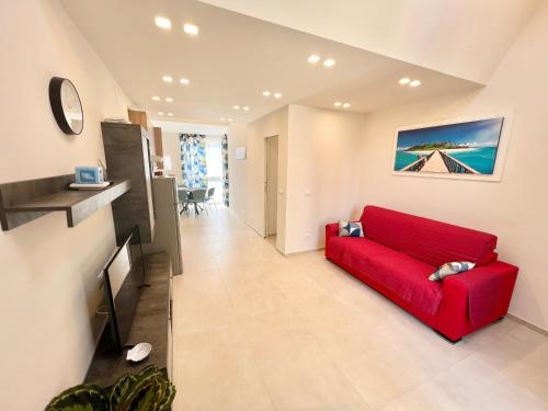 ein Wohnzimmer mit einem roten Sofa und einem TV in der Unterkunft Isola in Rapallo