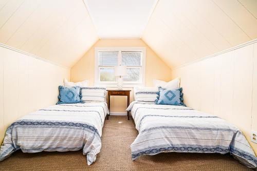 Zimmer im Dachgeschoss mit 3 Betten und blauen Kissen in der Unterkunft East Bay View Annex in Petoskey