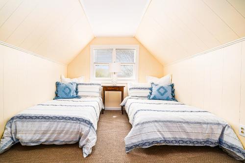 a attic room with three beds with blue pillows at East Bay View Annex in Petoskey