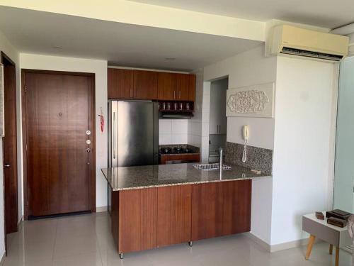 cocina con armarios de madera y nevera de acero inoxidable en Apartamento morros 922, en Cartagena de Indias