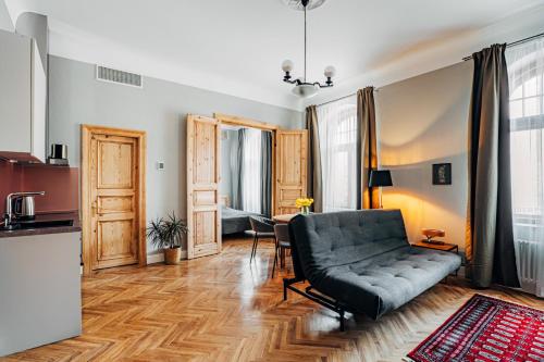a living room with a couch and a kitchen at Constantine Apartments in Rīga