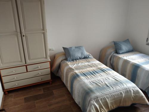 a bedroom with two beds and a dresser at Apartamento Aitue in Gijón